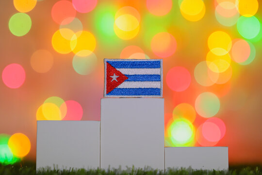 The Cuba national flag on a first place winner podium with festive bokeh lights. A powerful commercial concept symbolizing caribbean achievement, global success and cultural pride.