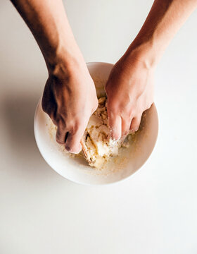 Hands mixing flour in a bowl for homemade dough, simple baking preparation with natural ingredients and copy space
