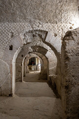 Obraz premium Naples, italy. December 29, 2024. Naples subterranean archaeological pathways with historic roman arches and stone walls, a journey into ancient history and architecture