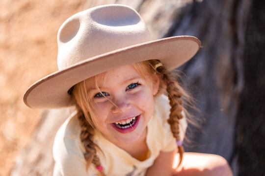 Happy portrait of Australian child in rural location looking up with bright blue eyes