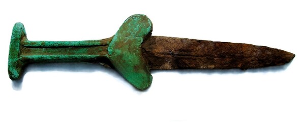 Macro shot of ancient bimetallic dagger hilt with green bronze patina and rusty iron blade isolated on white background. © Павел Дзюба