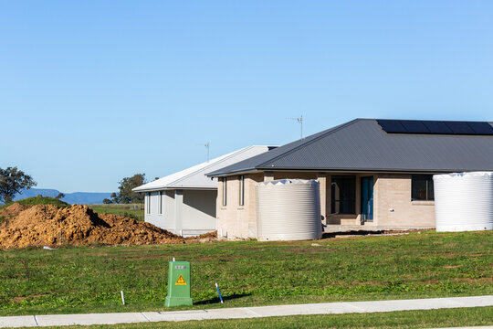 Two new house builds under construction by empty lot