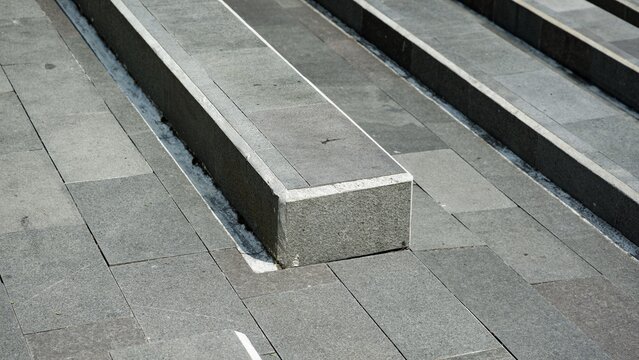 A clean pattern of repeating parallel lines and textured grey surfaces on a modern architectural terrace system.