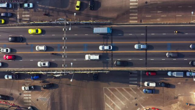Busy expressway traffic captured in an aerial view showcases congested multi-lane highway conditions during daylight hours within bustling urban setting with numerous vehicles.