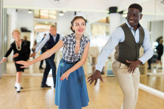 Man and woman performing jazz dance in dancing room