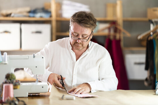 Man seamstress work with scissors and cutting