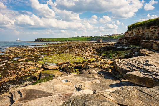 Rocks of Collywell Bay at Seaton Sluice, a village on the Northumberland coastline, with a rugged shore at Collywell Bay