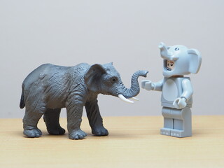 Naklejka premium Indonesia - May 27, 2026 : Mini toy of action figure at table with blur background. Miniature photography concept design. Minifigure of elephant character at wild life. Animal photo at nature.