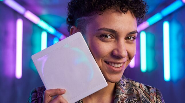 dvd bluray case mockup blank cover copyspace packaging person neon smiling young adult presents two white media cases under colorful lights for entertainment branding movie campaigns and cover design