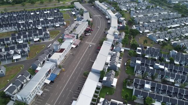 Aerial view of a contemporary residential suburban neighborhood layout featuring organized rows of modern houses and an empty central street