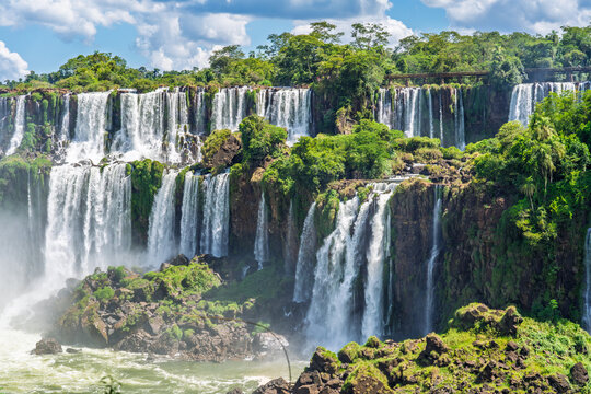 Scenic view of a large tropical waterfall in Brazil surrounded by lush green rainforest and rocky cliffs