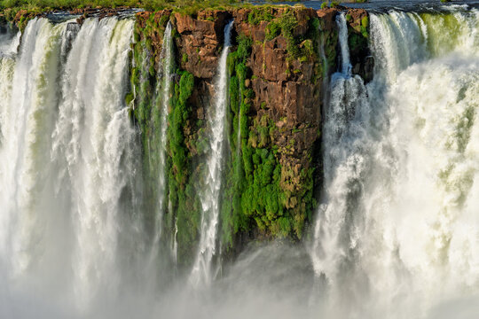 Powerful waterfall cascading over a rocky cliff with lush green vegetation in Brazil