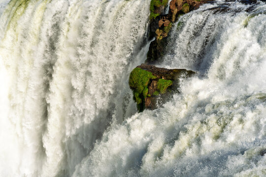 Powerful waterfall cascading over rocky cliffs with lush green vegetation in Brazil