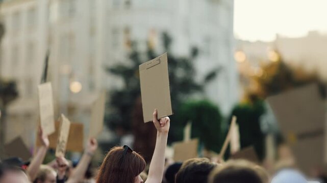 People gather for a protest with signs raised