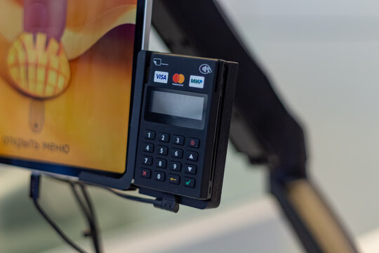 Modern electronic payment terminal with credit card reader attached to a digital screen in a store or cafe
