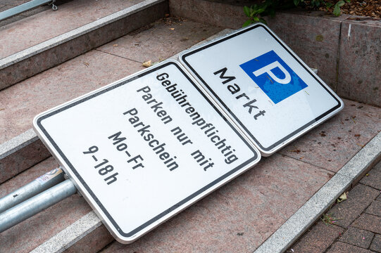 Sign for parking rules at a marketplace area lying on the ground with information about payment and schedule