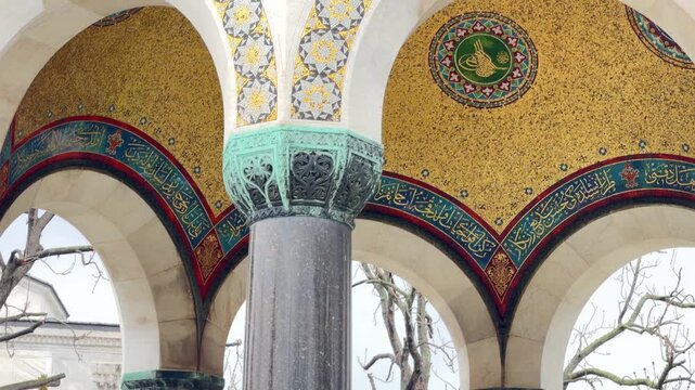 Slow zoom shot detailing the ornate golden mosaic ceiling and intricate calligraphy of the monumental German Fountain in Sultanahmet Square, Istanbul, Turkey.