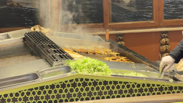 Static close-up shot of a street vendor grilling fresh fish and preparing traditional Balik Ekmek with steam rising in the historic Eminonu district of Istanbul, Turkey.