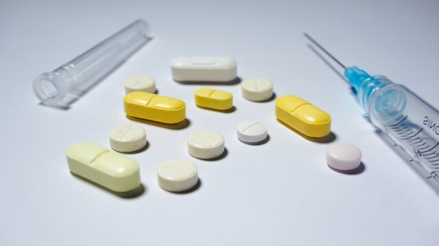 Some medicines with a sryinge on white surface. Medical concept.