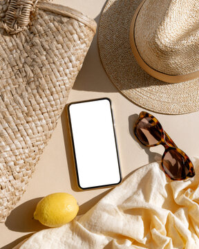 Smartphone blank screen mockup with straw hat sunglasses lemon and summer beach accessories
