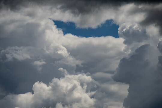 Fluffy white cumulus and dark dramatic storm clouds gathering in the atmosphere capturing concepts of meteorological transition and nature power