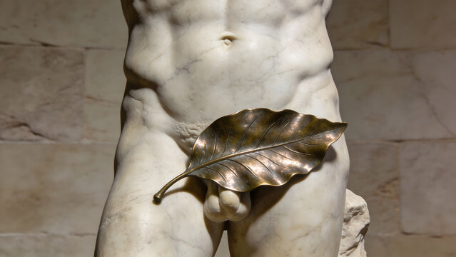 Classical marble sculpture of a male torso with bronze leaf covering.