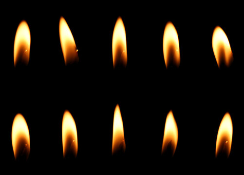 A realistic burning candle with a glowing orange and gold flame, isolated on a black background. light effect candle fire flame