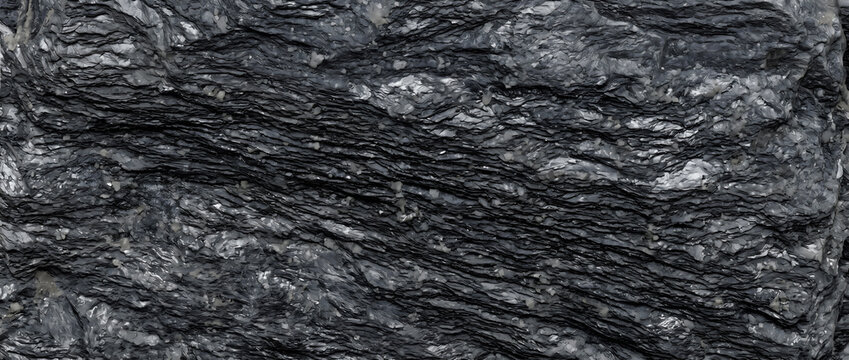 Black stone texture showing a close up of a rough natural slate rock wall surface with detailed wavy organic layers offers a premium dark backdrop for design layouts