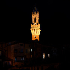 Obraz premium The iconic Torre del Mangia, which towers over the Palazzo Pubblico in the Piazza del Campo in Siena, Italy, Nightview