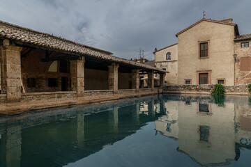 Obraz premium The Piazza delle Sorgenti, the central square with an ancient thermal pool in Bagno Vignoni, Italy