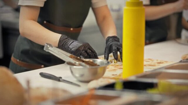 At a fast-food restaurant, a team of cooks prepares shawarma, wrapping the meat and vegetable filling in thin lavash bread. The fast-food concept is to deliver orders to customers