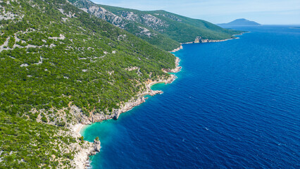 Obraz premium Breathtaking aerial view of Croatia's lush, forested coastline meeting the crystal-clear Adriatic Sea. Secluded coves and turquoise waters invite exploration under the summer sun. Blue cave, Cres