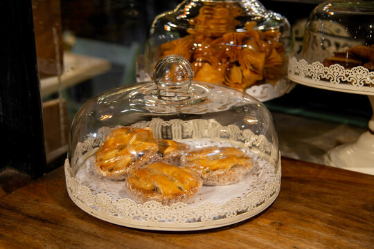 Mini pasta frola quince tarts displayed under glass cloche dome