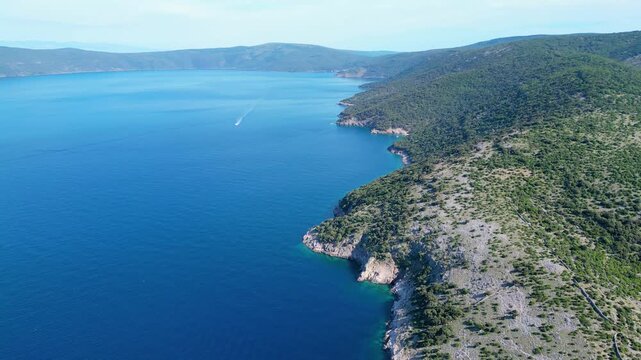 Breathtaking aerial view of Croatia's Adriatic coast. Lush green hills meet crystal-clear turquoise waters, revealing hidden coves and distant sailboats under a summer sky. Beach Grabrovica
