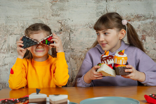 Kids enjoy dessert time while playing with colorful treats in a bright indoor space on a weekend