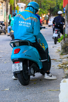 Da Nang, Vietnam - January 15, 2026: A taxi driver in a company uniform on a VinFast Evo 200 electric scooter from Xanh SM taxi service in Danang, Vietnam.