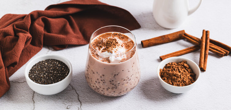 Overnight oats with chia seeds and cinnamon in a glass on the table web banner