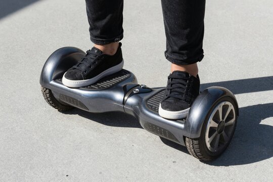 Person Riding Hoverboard on Urban Surface