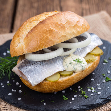 A delicious traditional German Matjes herring roll with fresh onion rings, crunchy gherkins, and a creamy dill sauce.