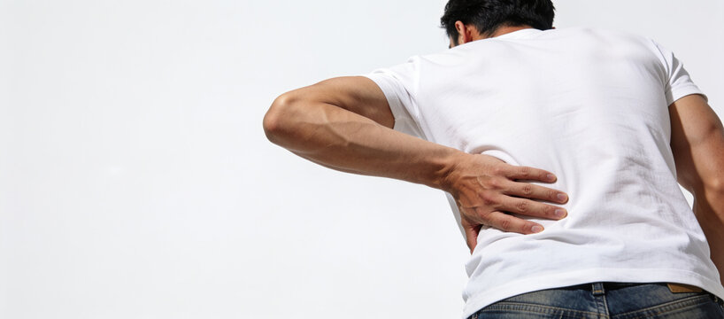Man bending forward while holding his lower back with both hands, representing physical discomfort and back pain