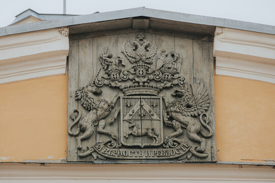 Rundale, Latvia - July 18, 2026: Ornate stone coat of arms featuring lions, a double-headed eagle, and a shield, mounted on a yellow wall in a historical building