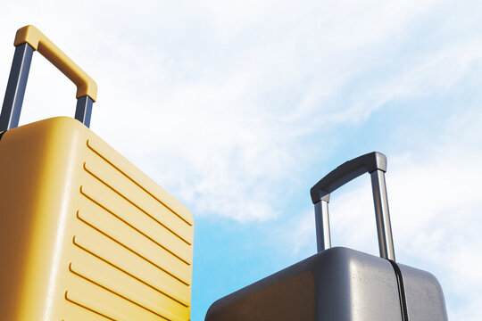 Yellow and dark grey suitcases with telescopic handles against bright blue sky with clouds symbolizing summer holiday travel and tourism. 3D Rendering