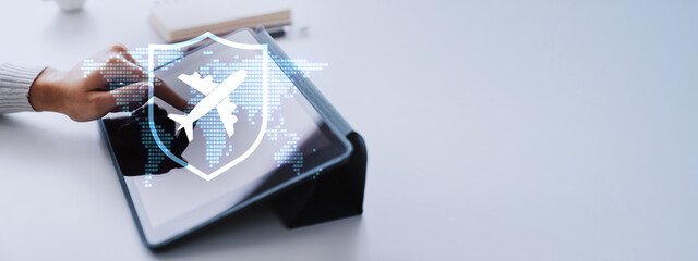 Fototapeta na wymiar Woman using tablet with airplane and shield hologram over dotted world map on light banner with copy space showing travel insurance and safe flight booking.
