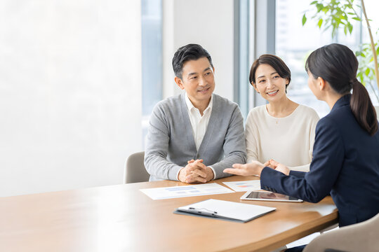 保険や資産運用の相談を受けるミドル夫婦の面談風景