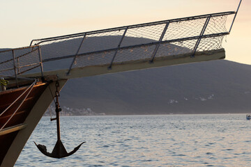 Bowsprit and Hanging Anchor of a Wooden Sailing Ship Against the Sea and Mountains © Predrag
