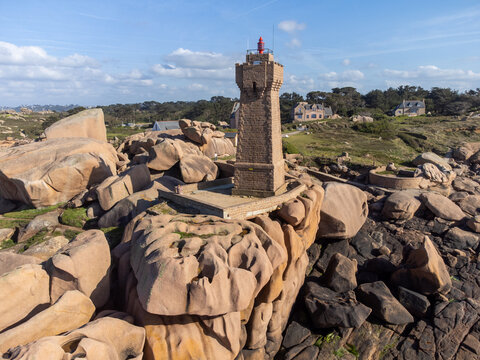 Aerial view, Lighthouse of Heap of Ploumanac'h and Chateau de Costaeres iconic pink granite rock formation on C&ocirc;te de Granit Rose, Brittany. Massive balanced boulders on seashore, France