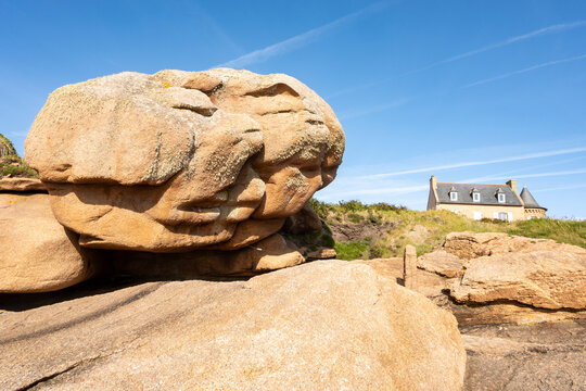 Heap of Ploumanac'h and Chateau de Costaeres iconic pink granite rock formation on C&ocirc;te de Granit Rose, Brittany. Massive balanced boulders creating natural sculptural monument on seashore, France