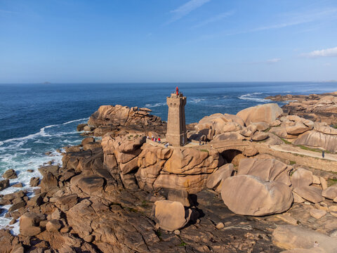 Aerial view, Lighthouse of Heap of Ploumanac'h and Chateau de Costaeres iconic pink granite rock formation on C&ocirc;te de Granit Rose, Brittany. Massive balanced boulders on seashore, France