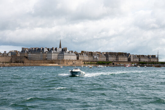 High tide in Dinard, Brittany with view toward walled city of Saint-Malo. Coastal Atlantic landscape with boats and dramatic tidal range of Emerald Coast, France.