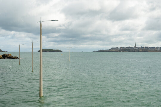 High tide in Dinard, Brittany with view toward walled city of Saint-Malo. Coastal Atlantic landscape with boats and dramatic tidal range of Emerald Coast, France.